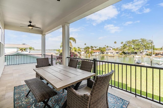 balcony with ceiling fan and a water view