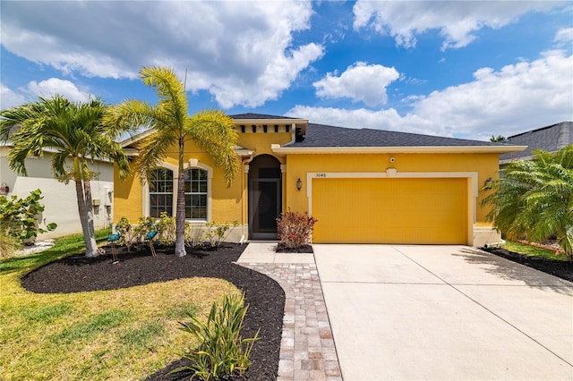 mediterranean / spanish home with stucco siding, an attached garage, and driveway
