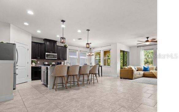 kitchen with dark cabinetry, recessed lighting, appliances with stainless steel finishes, and a breakfast bar