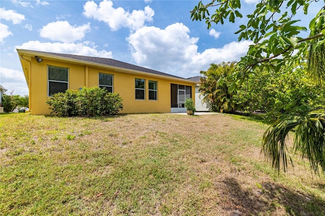 5048 Inshore Landing Dr, Apollo Beach, FL 33572 - rear view of property featuring stucco siding, a lawn, and a sunroom