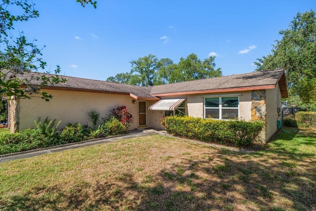 ranch-style house featuring stucco siding and a front yard