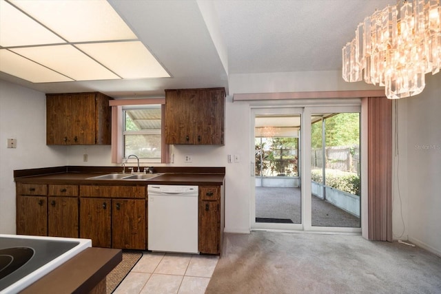 kitchen featuring dishwasher, dark countertops, plenty of natural light, and a sink