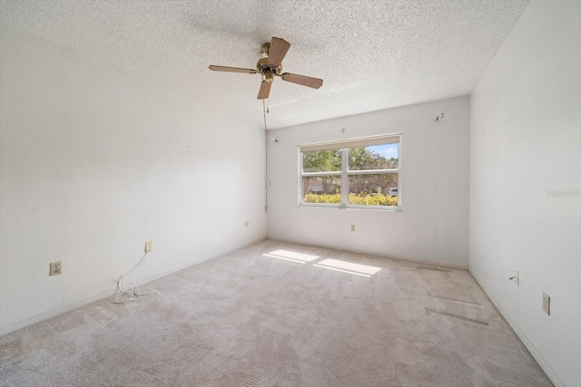 carpeted empty room with a ceiling fan and a textured ceiling