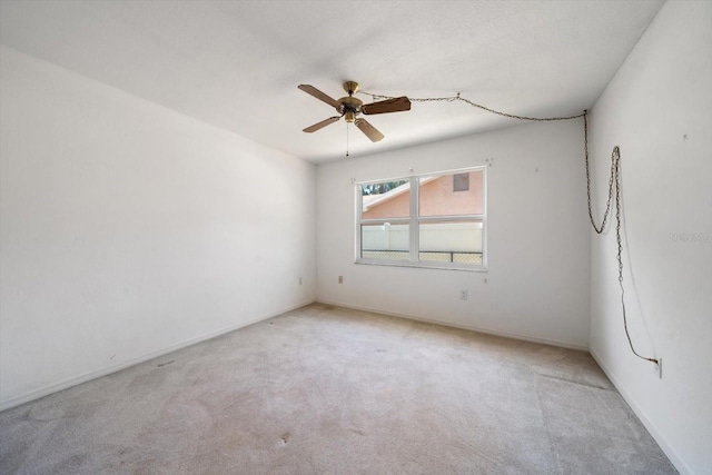 empty room featuring ceiling fan, carpet flooring, and baseboards