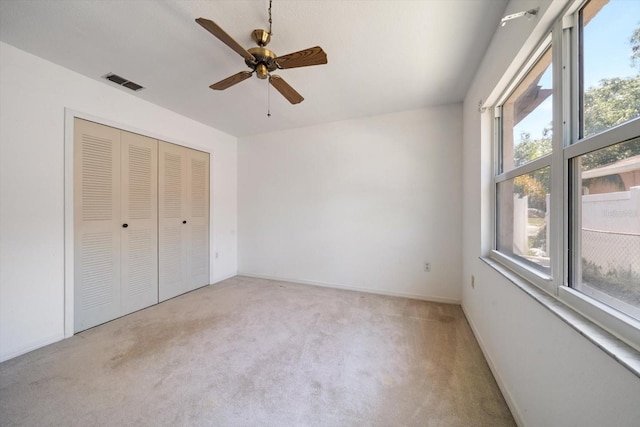 unfurnished bedroom featuring carpet flooring, a closet, visible vents, and multiple windows
