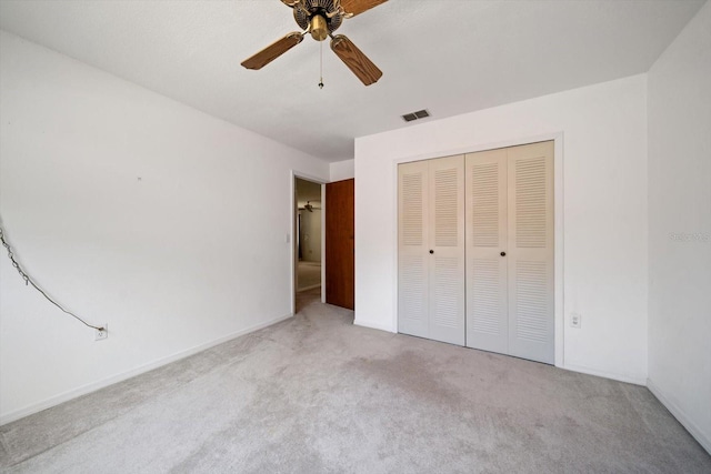 unfurnished bedroom with a closet, visible vents, ceiling fan, and carpet floors