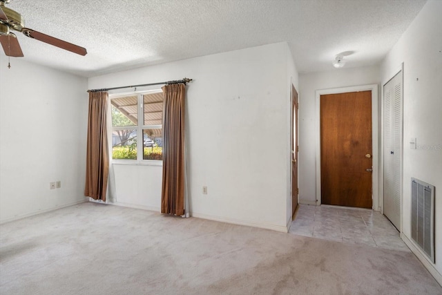 spare room featuring a ceiling fan, a textured ceiling, visible vents, and carpet