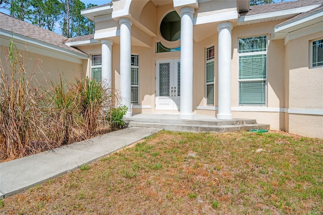 7340 W Dr, Wesley Chapel, FL 33544 - view of exterior entry with stucco siding, roof with shingles, french doors, and a porch