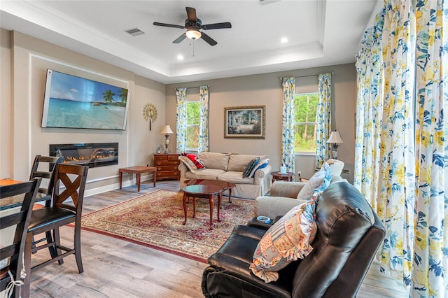 7340 W Dr, Wesley Chapel, FL 33544 - living area featuring a raised ceiling, a wealth of natural light, ceiling fan, and wood finished floors
