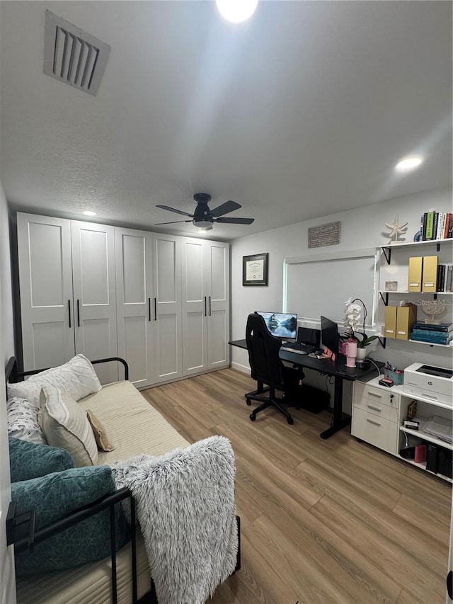 office space with ceiling fan, visible vents, and light wood-type flooring