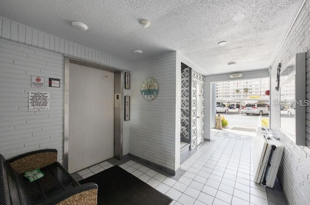 5925 Shore Blvd S Unit 602, Gulfport, FL 33707 - corridor featuring light tile patterned floors, elevator, and a textured ceiling