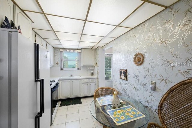 5925 Shore Blvd S Unit 602, Gulfport, FL 33707 - kitchen with a sink, wallpapered walls, stove, light countertops, and light tile patterned flooring