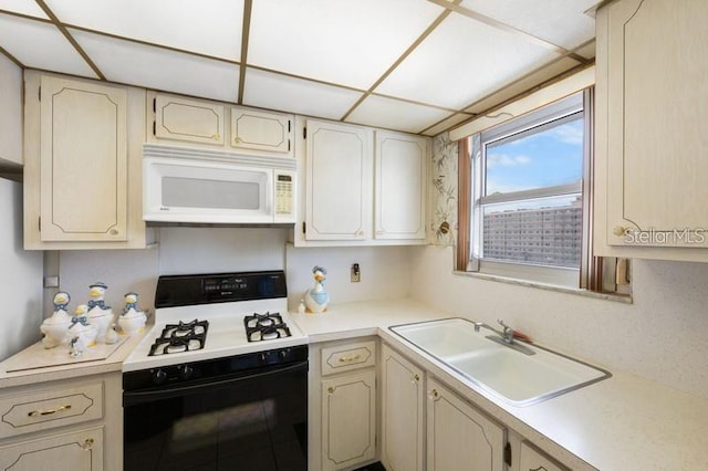 5925 Shore Blvd S Unit 602, Gulfport, FL 33707 - kitchen with white microwave, a sink, light countertops, and black gas range oven