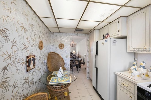 5925 Shore Blvd S Unit 602, Gulfport, FL 33707 - kitchen with freestanding refrigerator, wallpapered walls, a notable chandelier, light countertops, and light tile patterned flooring