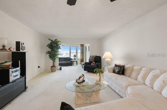 5925 Shore Blvd S Unit 602, Gulfport, FL 33707 - living room featuring a textured ceiling, carpet, and a ceiling fan