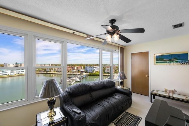 5925 Shore Blvd S Unit 602, Gulfport, FL 33707 - living area with a water view, a textured ceiling, visible vents, and a ceiling fan