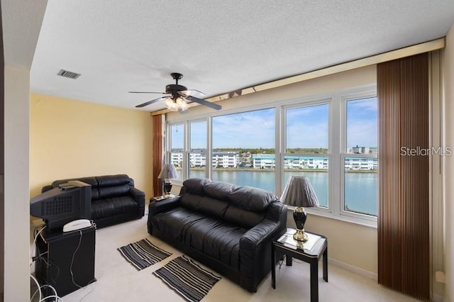 5925 Shore Blvd S Unit 602, Gulfport, FL 33707 - living area with a textured ceiling, visible vents, light carpet, a ceiling fan, and a water view