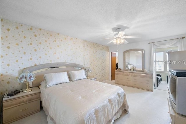 5925 Shore Blvd S Unit 602, Gulfport, FL 33707 - bedroom featuring light colored carpet, wallpapered walls, a textured ceiling, and a ceiling fan