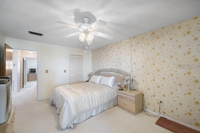 5925 Shore Blvd S Unit 602, Gulfport, FL 33707 - bedroom featuring wallpapered walls, a textured ceiling, baseboards, visible vents, and light colored carpet