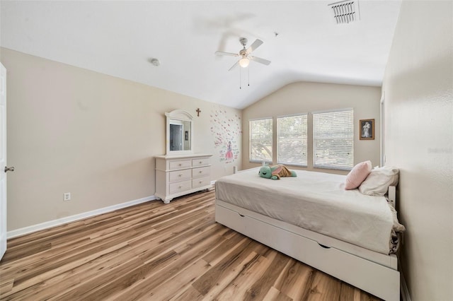 bedroom with vaulted ceiling, light wood-style floors, baseboards, and ceiling fan