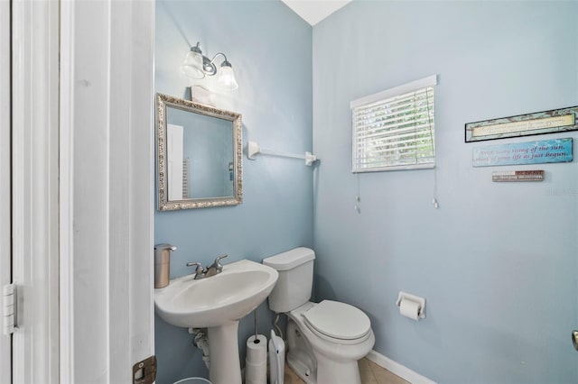 bathroom with toilet, tile patterned flooring, and baseboards