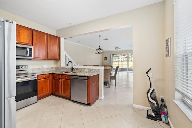 kitchen featuring stainless steel appliances, a sink, a peninsula, light stone countertops, and baseboards