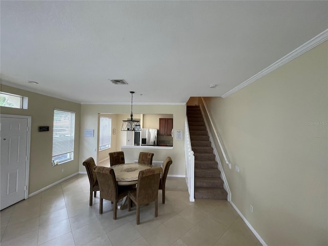 dining area featuring crown molding, baseboards, a chandelier, stairs, and light tile patterned floors