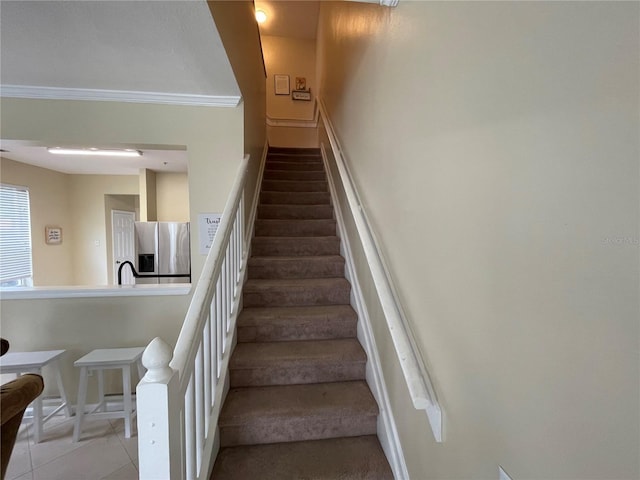 stairs featuring crown molding and tile patterned flooring
