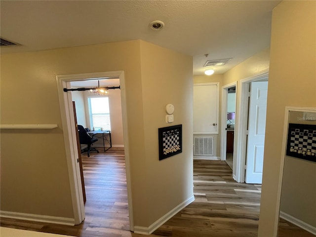 corridor with wood finished floors and baseboards