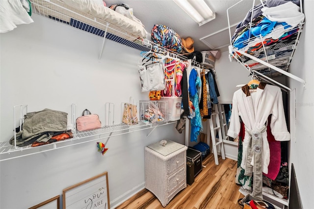 walk in closet with wood finished floors