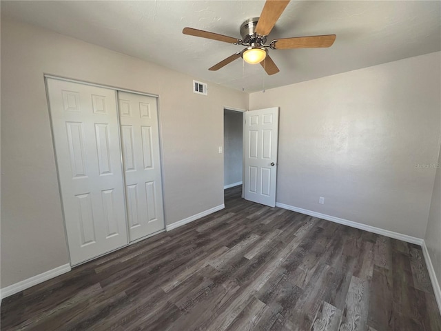 unfurnished bedroom with a ceiling fan, a closet, baseboards, visible vents, and dark wood-type flooring