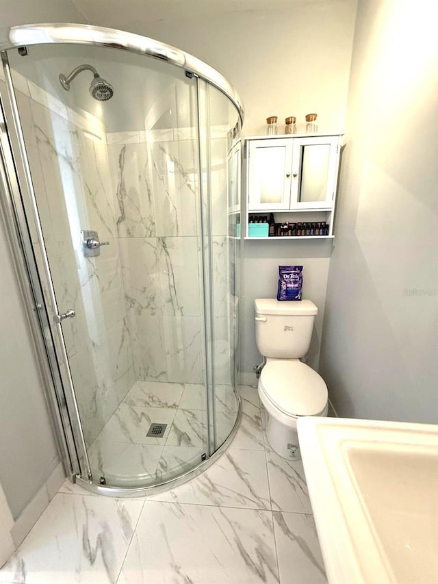 full bathroom featuring marble finish floor, a marble finish shower, and toilet