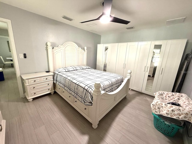 bedroom featuring ceiling fan, wood finished floors, and visible vents
