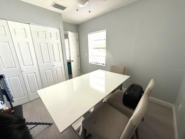 office with ceiling fan, visible vents, baseboards, and light wood-type flooring