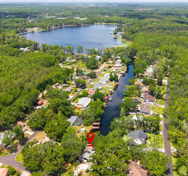 drone / aerial view with a water view, a residential view, and a wooded view