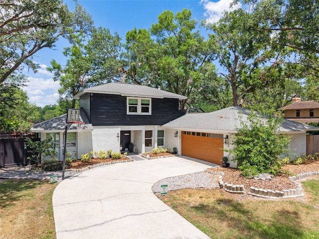 view of front of house featuring driveway, brick siding, fence, a garage, and a porch