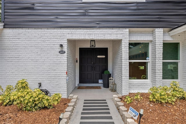 doorway to property featuring brick siding