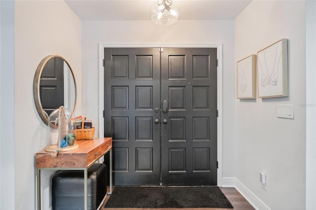 entryway with dark wood-type flooring and baseboards