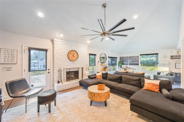 living room featuring wood finished floors, a ceiling fan, high vaulted ceiling, a brick fireplace, and recessed lighting