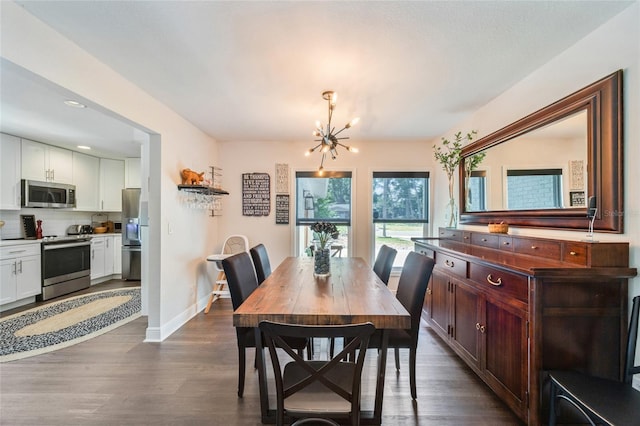 dining area featuring baseboards, a notable chandelier, dark wood finished floors, and recessed lighting