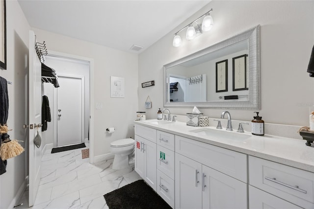 full bath with double vanity, toilet, marble finish floor, and a sink