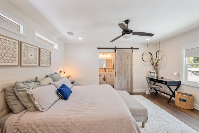 bedroom featuring wood finished floors, visible vents, a barn door, baseboards, and recessed lighting