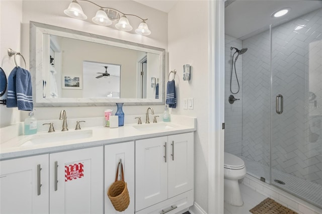 full bath featuring a sink, double vanity, a shower stall, and a ceiling fan