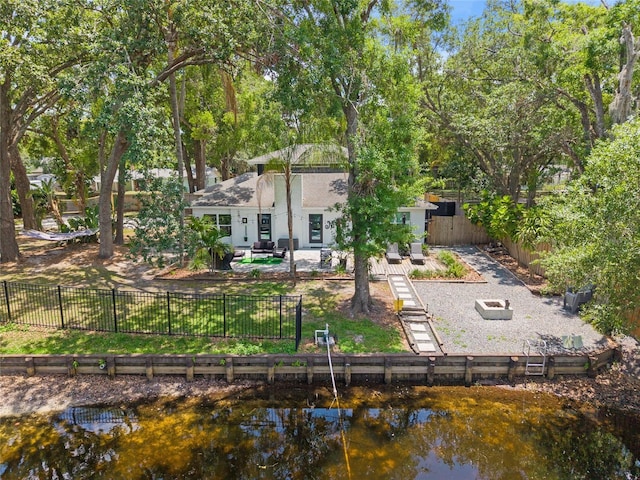 rear view of property featuring a patio, a water view, and a fenced backyard