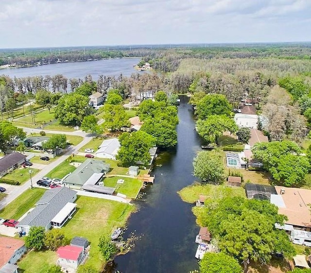 drone / aerial view with a wooded view, a water view, and a residential view