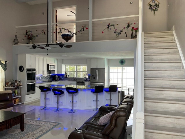 11727 Spanish Lake Dr, Tampa, FL 33635 - living area featuring ceiling fan, a high ceiling, and stairway