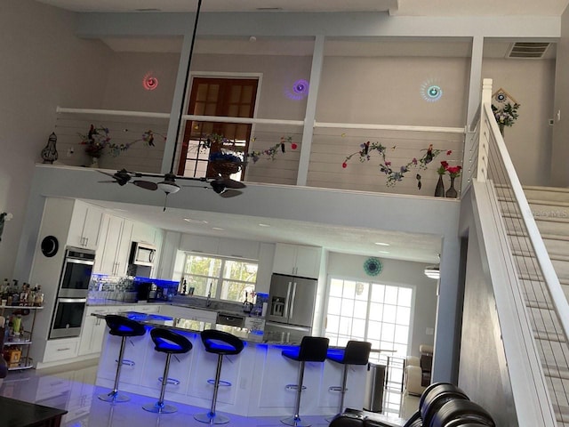 11727 Spanish Lake Dr, Tampa, FL 33635 - kitchen with visible vents, a ceiling fan, appliances with stainless steel finishes, and white cabinets