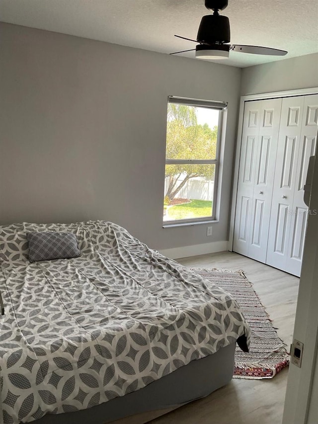 11727 Spanish Lake Dr, Tampa, FL 33635 - bedroom with a closet, a ceiling fan, light wood-style floors, and baseboards