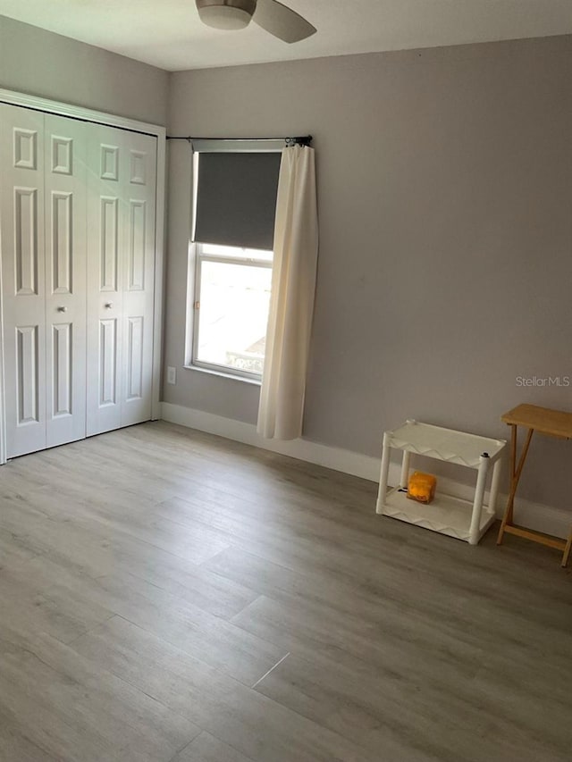 11727 Spanish Lake Dr, Tampa, FL 33635 - unfurnished bedroom with baseboards, wood finished floors, and a closet