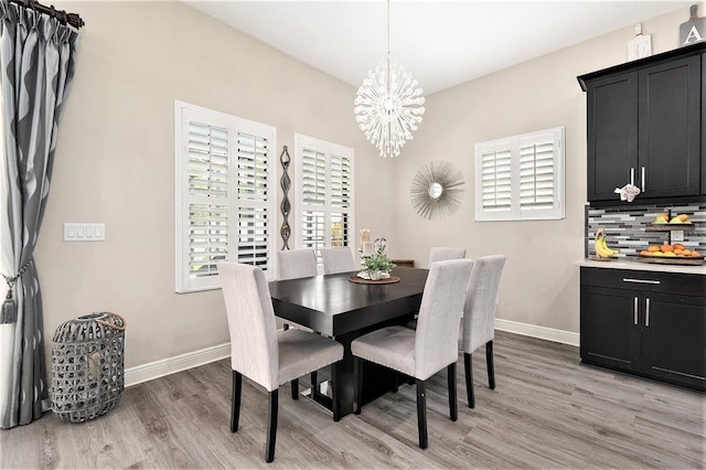 dining area with an inviting chandelier, light wood-style flooring, and baseboards